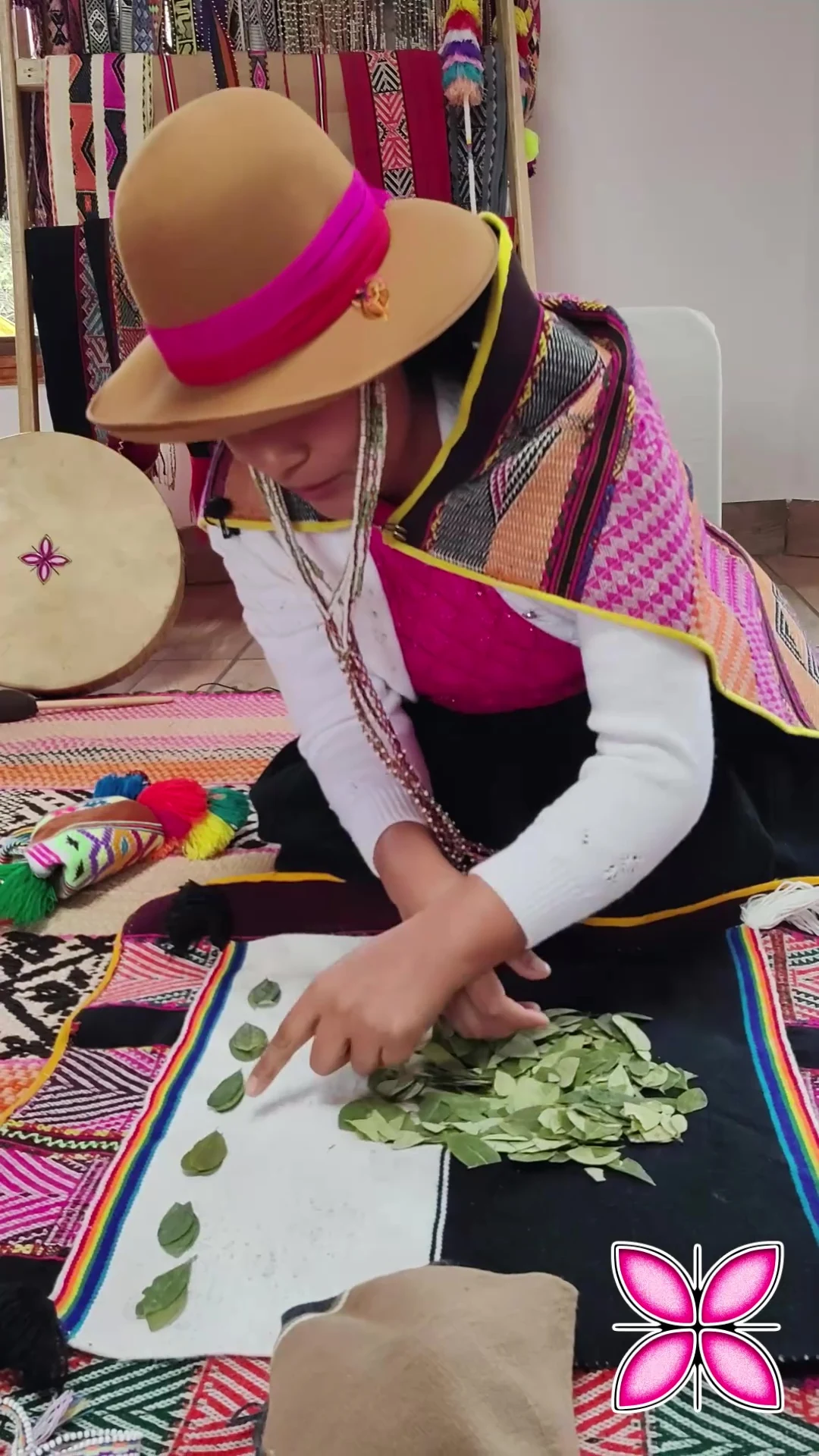 Leonarda trabajando con hojas de coca y una missa andina abierta.