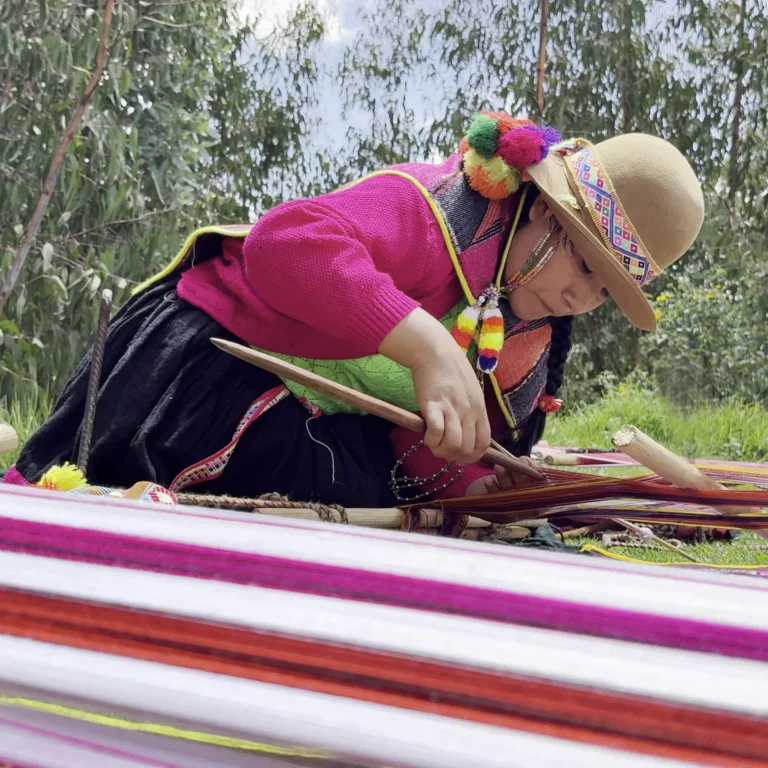 Leonarda Pauccar tejiendo al aire libre en un telar de cintura.